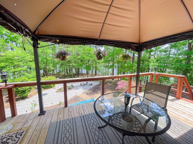 deck featuring outdoor dining area and a gazebo