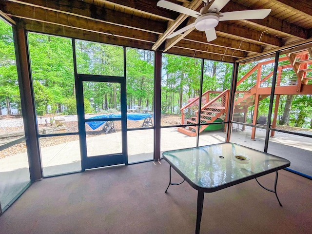 unfurnished sunroom featuring ceiling fan and a wealth of natural light