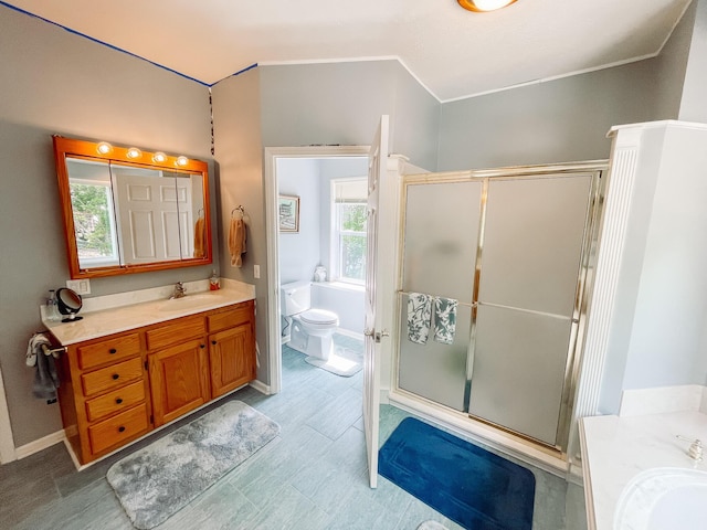 full bath featuring toilet, vanity, ornamental molding, and a stall shower