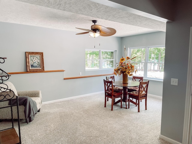 dining space featuring a ceiling fan, carpet flooring, a textured ceiling, and baseboards