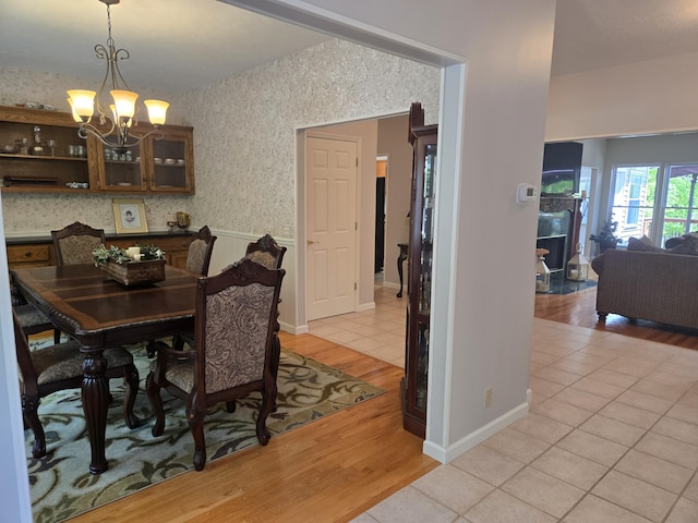 dining area featuring baseboards, an inviting chandelier, and light wood finished floors