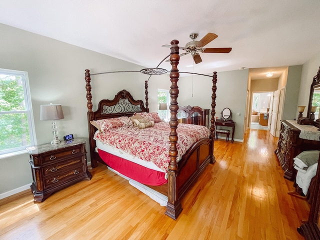 bedroom with baseboards, light wood-type flooring, and a ceiling fan