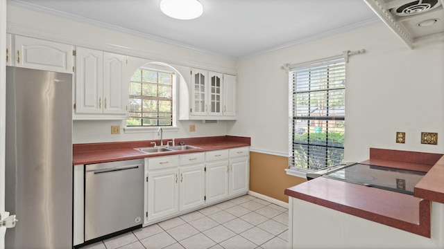 kitchen with a sink, ornamental molding, a wealth of natural light, and stainless steel appliances