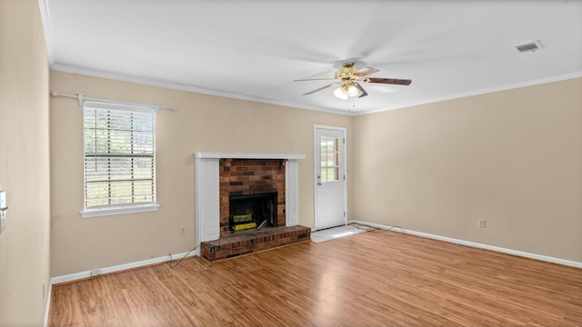 unfurnished living room featuring a healthy amount of sunlight, visible vents, a ceiling fan, and wood finished floors