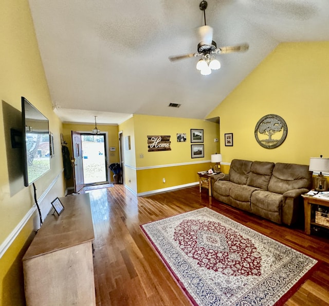 living room featuring hardwood / wood-style flooring, ceiling fan, a textured ceiling, and vaulted ceiling