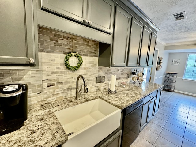 kitchen featuring sink, gray cabinets, light tile patterned floors, a textured ceiling, and black dishwasher