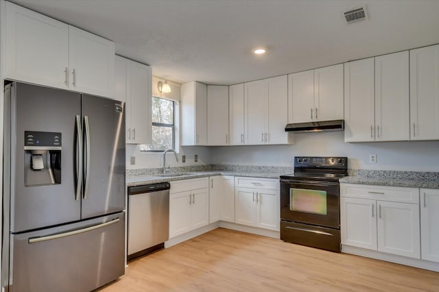 kitchen featuring under cabinet range hood, white cabinetry, appliances with stainless steel finishes, and a sink