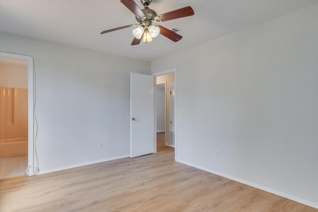 spare room with light wood-style flooring, visible vents, baseboards, and a ceiling fan