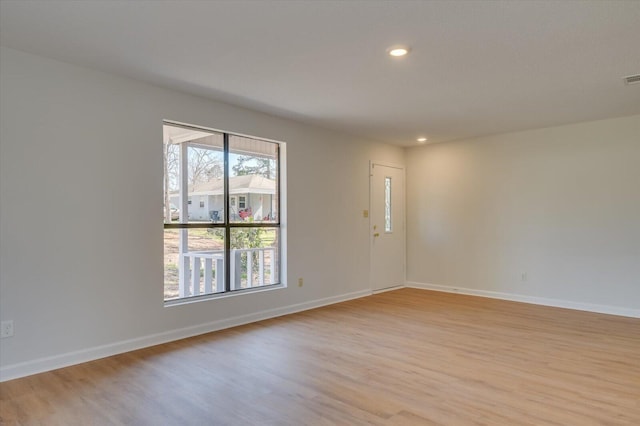 spare room with recessed lighting, light wood-style flooring, and baseboards