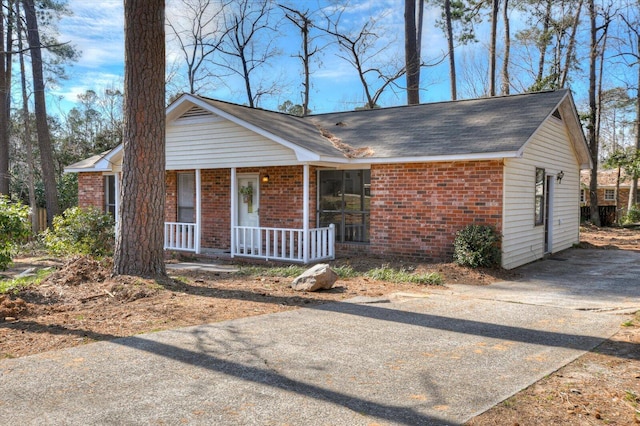 single story home with covered porch and brick siding