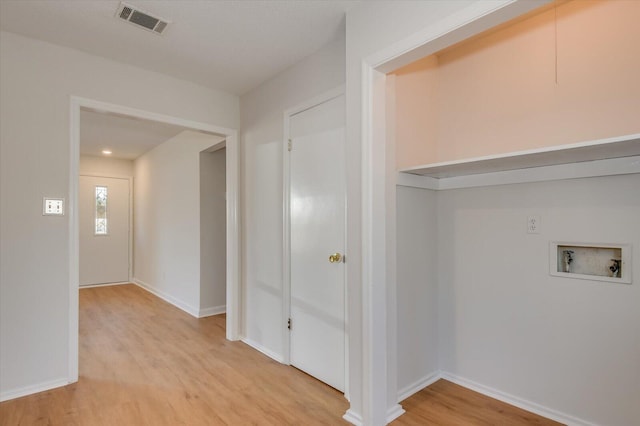 interior space featuring laundry area, baseboards, visible vents, light wood-type flooring, and washer hookup