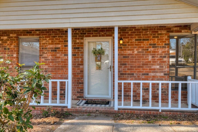 view of exterior entry featuring brick siding