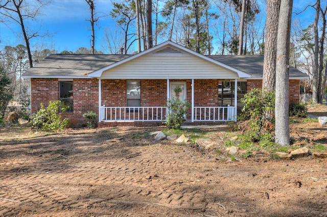 ranch-style home with a porch and brick siding