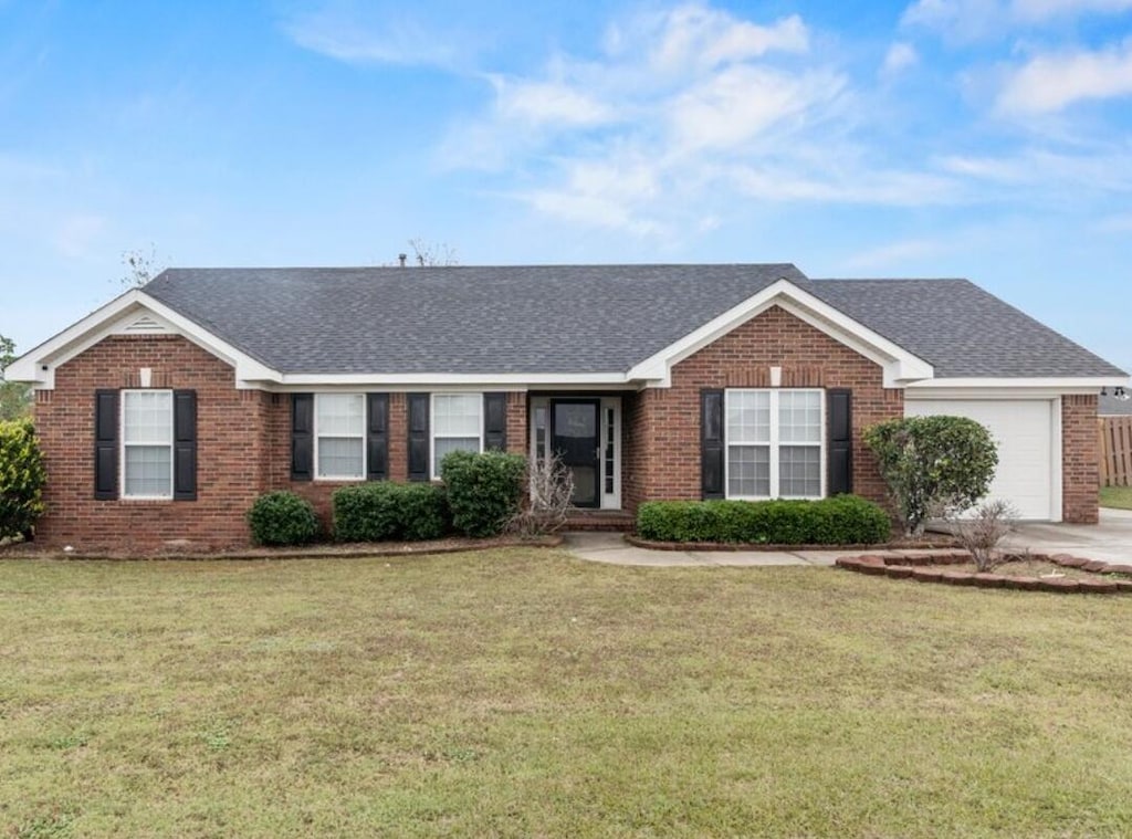 ranch-style house with a garage and a front yard