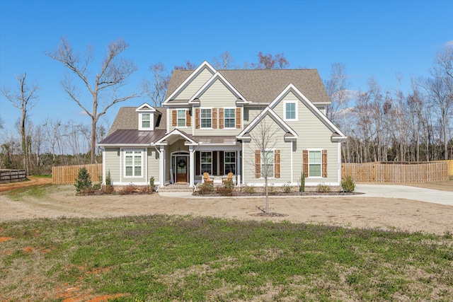 view of front of house with metal roof, roof with shingles, fence, and a front lawn