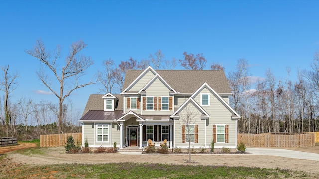 view of front of home with metal roof and fence