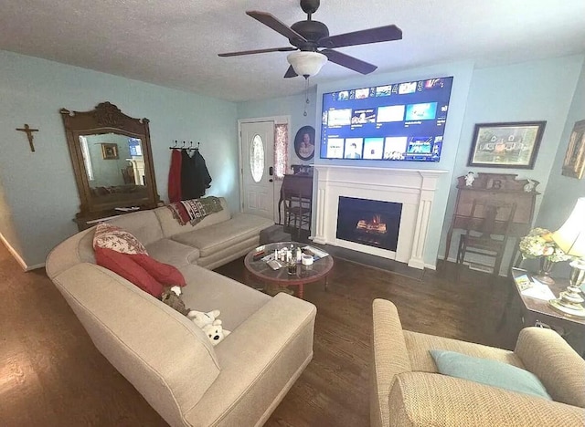 living room featuring a fireplace with flush hearth, wood finished floors, a ceiling fan, and baseboards