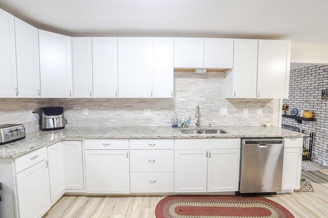 kitchen featuring sink, stainless steel dishwasher, white cabinets, and light hardwood / wood-style flooring