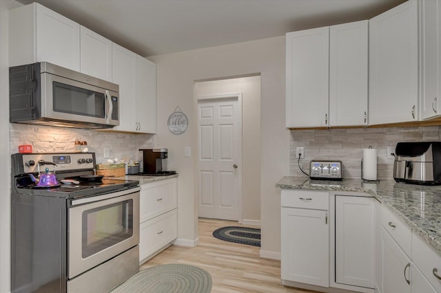2107 Brown Rd, Hephzibah, GA 30815 - kitchen with light stone counters, white cabinets, stainless steel appliances, and backsplash