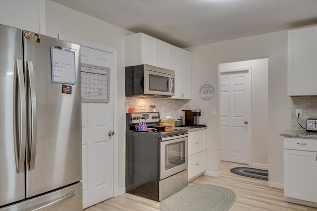 2107 Brown Rd, Hephzibah, GA 30815 - kitchen with light wood-type flooring, backsplash, stainless steel appliances, white cabinets, and light stone countertops