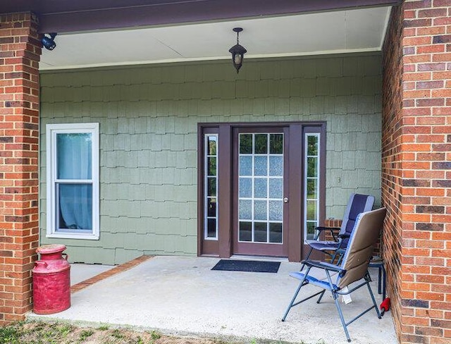 view of exterior entry with a patio