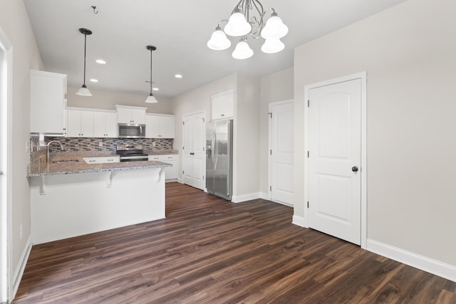 501 Cranberry Cir, Grovetown, GA 30813 - kitchen with appliances with stainless steel finishes, a peninsula, dark wood-style flooring, light stone countertops, and recessed lighting
