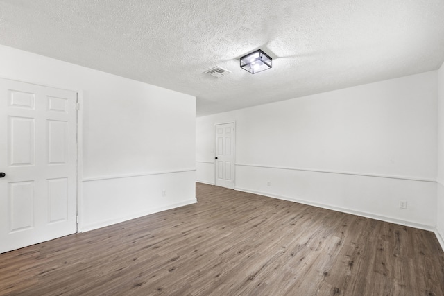 empty room featuring dark hardwood / wood-style floors and a textured ceiling