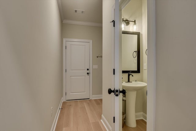 bathroom featuring hardwood / wood-style flooring, sink, and crown molding