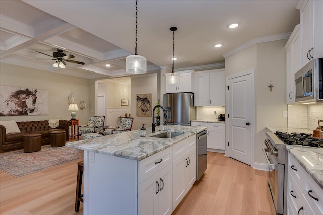 kitchen featuring beam ceiling, stainless steel appliances, coffered ceiling, an island with sink, and white cabinets