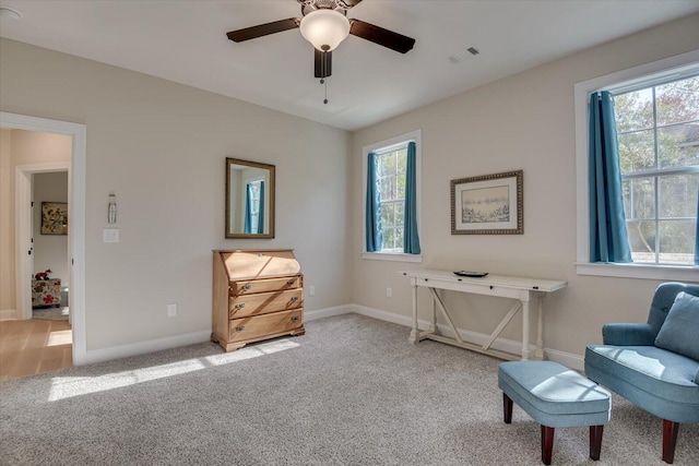 living area featuring ceiling fan and light colored carpet