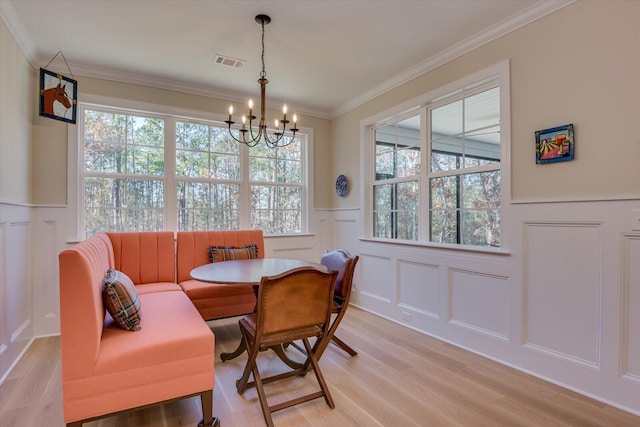 dining space with crown molding, a healthy amount of sunlight, and a notable chandelier