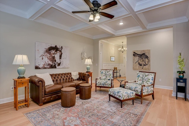 living room with coffered ceiling, beamed ceiling, light hardwood / wood-style floors, ceiling fan with notable chandelier, and ornamental molding