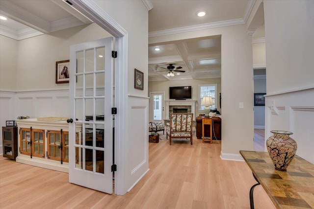 hallway with french doors, coffered ceiling, beamed ceiling, crown molding, and light wood-type flooring