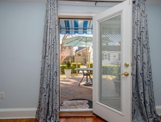 doorway to outside featuring baseboards