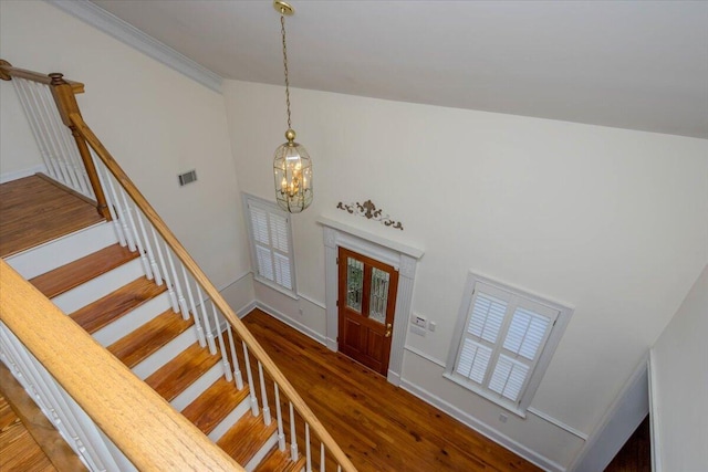 foyer entrance with visible vents, stairway, an inviting chandelier, dark wood-type flooring, and baseboards