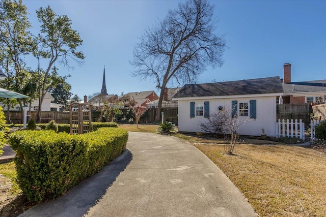 view of front of house featuring a front lawn and fence