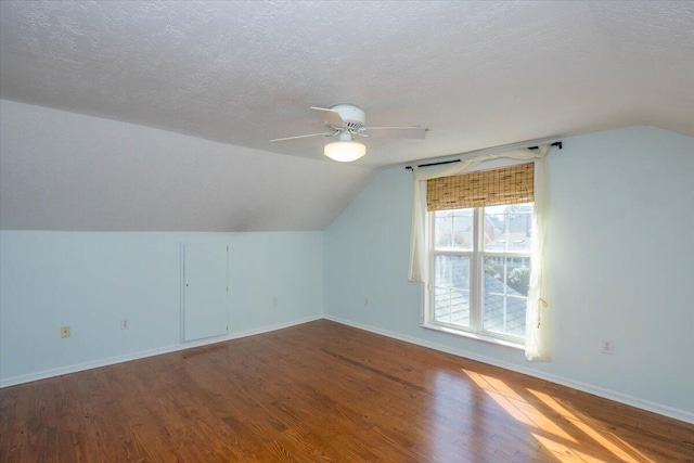 bonus room with lofted ceiling, a textured ceiling, baseboards, and wood finished floors