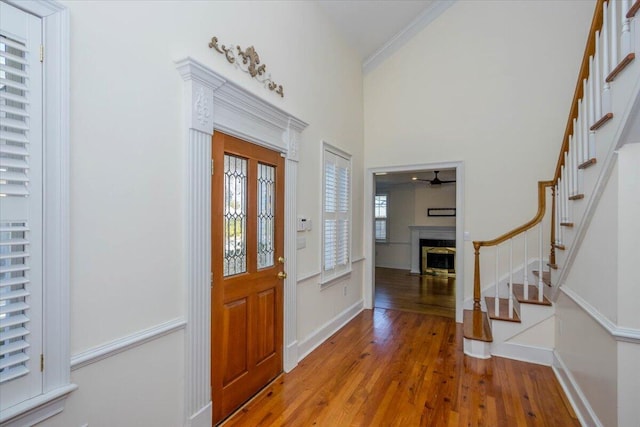 foyer with light wood-style floors, a fireplace, stairway, and baseboards