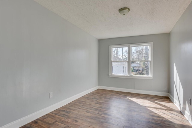 empty room with hardwood / wood-style flooring and a textured ceiling