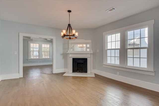 unfurnished living room with hardwood / wood-style floors and a chandelier