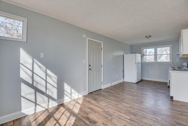 kitchen featuring wood-type flooring, white appliances, white cabinets, and a textured ceiling