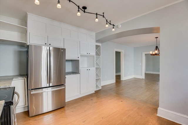 kitchen featuring light stone countertops, white cabinetry, electric stove, stainless steel refrigerator, and light hardwood / wood-style flooring