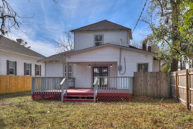 rear view of property with a deck and a lawn