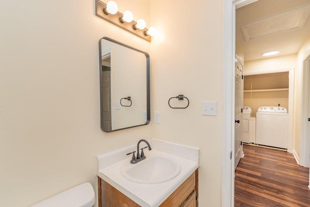 2421 Castlewood Dr, Augusta, GA 30904 - half bath featuring washer and clothes dryer, vanity, wood finished floors, and toilet