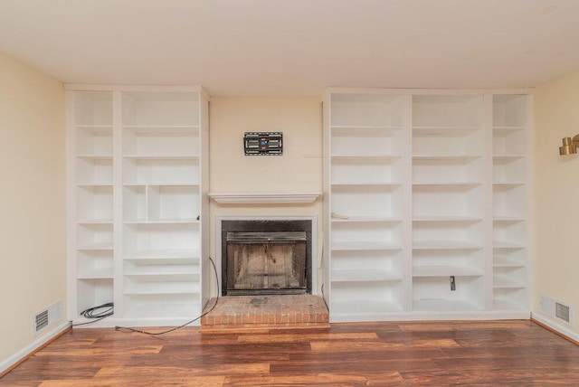 2421 Castlewood Dr, Augusta, GA 30904 - unfurnished living room with wood finished floors, a fireplace with raised hearth, built in features, and baseboards
