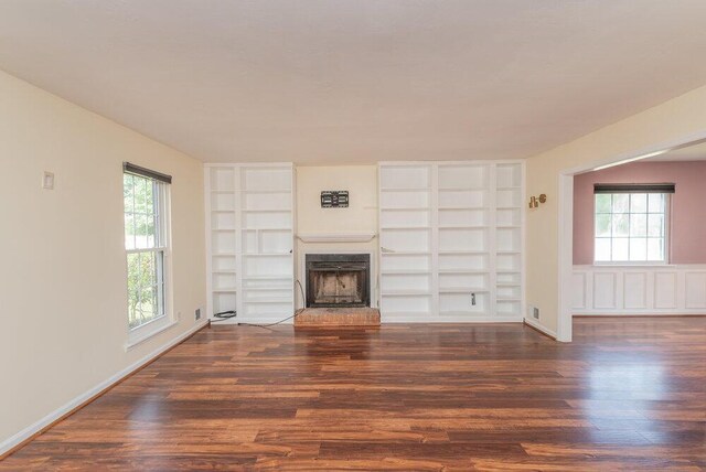 2421 Castlewood Dr, Augusta, GA 30904 - unfurnished living room with wood finished floors, built in shelves, and healthy amount of natural light