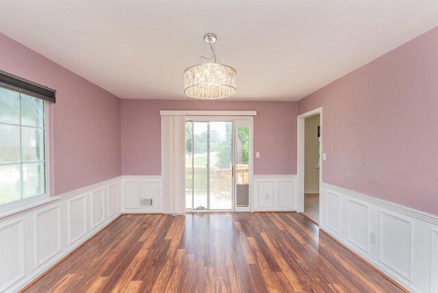 2421 Castlewood Dr, Augusta, GA 30904 - unfurnished dining area featuring a decorative wall, wainscoting, wood finished floors, and a chandelier