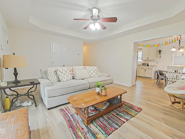 15 Whitney Ct, Augusta, GA 30904 - living room featuring a tray ceiling, light wood-type flooring, ceiling fan, and baseboards