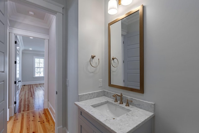 bathroom with vanity, wood-type flooring, and crown molding