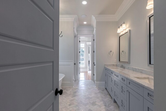 bathroom featuring a bathing tub, vanity, and crown molding